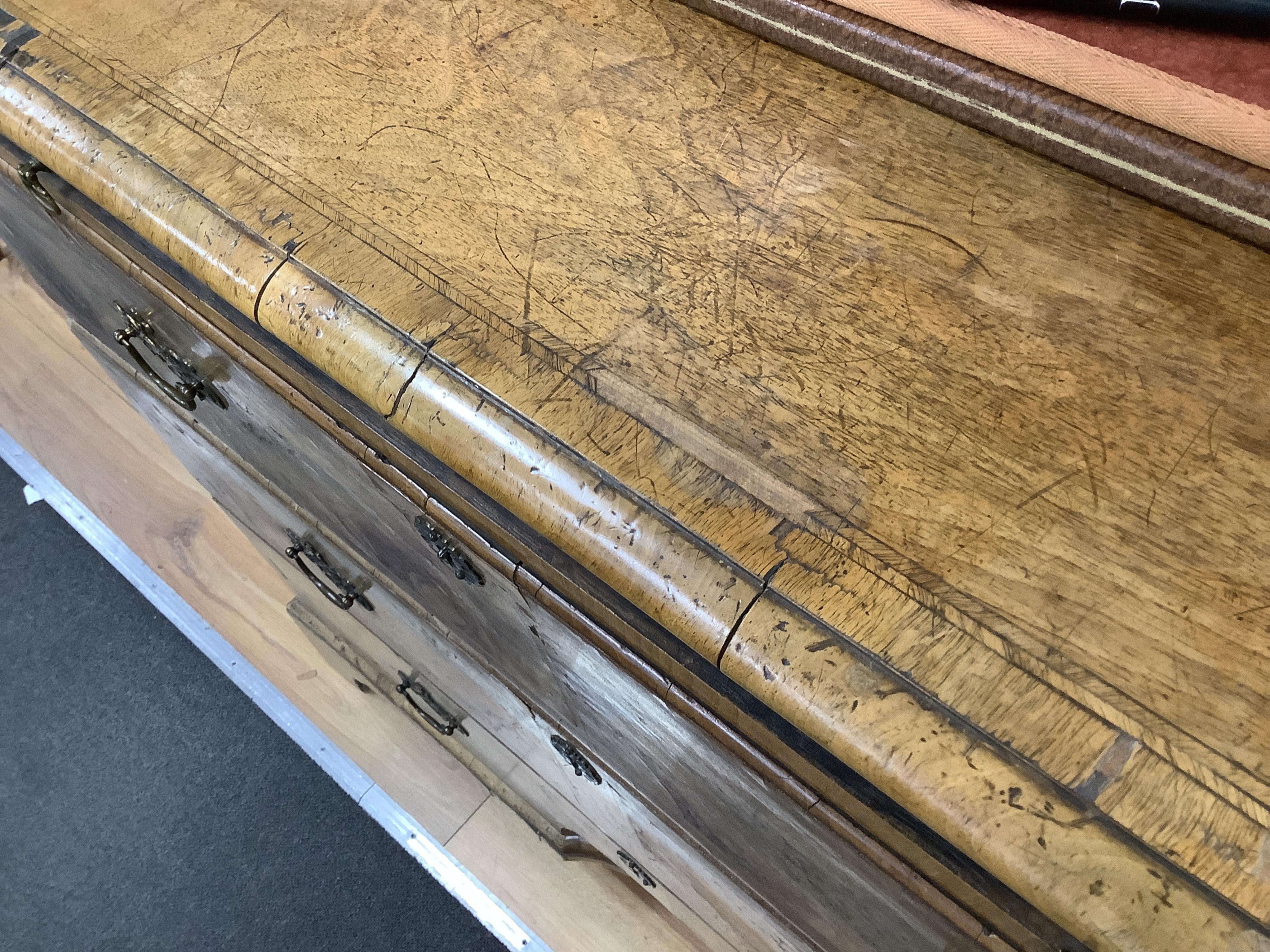 A mid 18th century feather banded walnut concave starburst walnut chest of three drawers, with brushing slide, width 108cm, depth 54cm, height 92cm